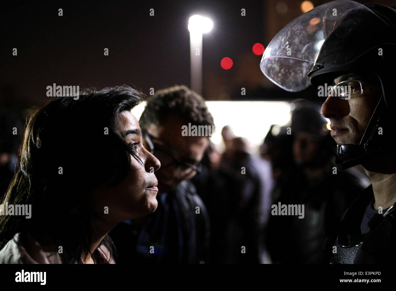 Una donna guarda con coraggio la sommossa poliziotto durante la loro protesta contro l'arresto di due persone durante la manifestazione contro il 2014 FIFA World Cup di Paulista Avenue in Sao Paulo, Brasile. Le persone riunite sotto il Museo di Arte di Sao Paulo prima di procedere con il Paulista Avenue ma sono impedito di marcia attraverso la città dalla polizia. (Foto di TIAGO Mazza Chiaravalloti/Pacific Stampa) Foto Stock