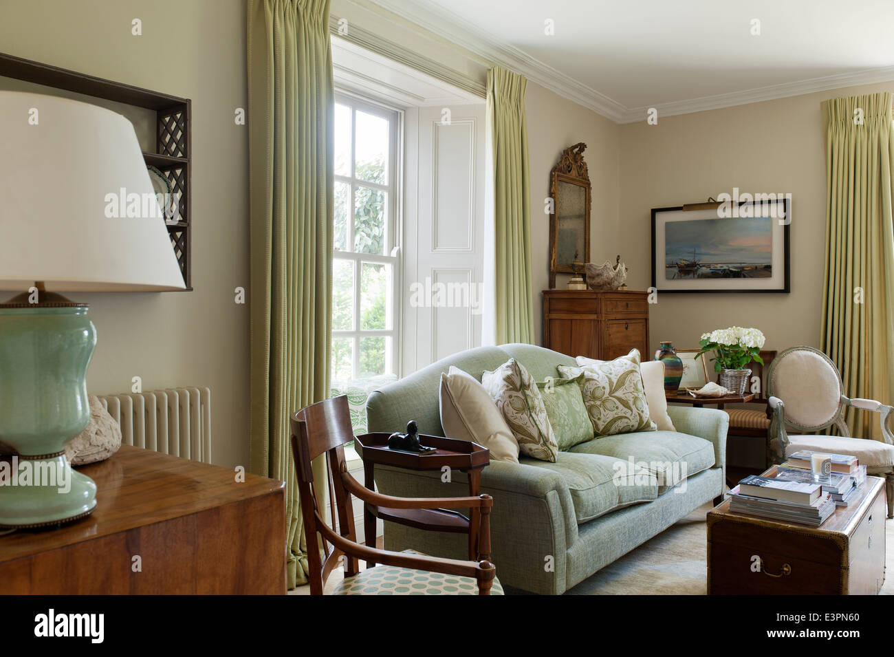 Grande divano verde verde con cuscini modellato in un elegante salotto. Il muro di vernice è una stringa da Farrow e sfera Foto Stock