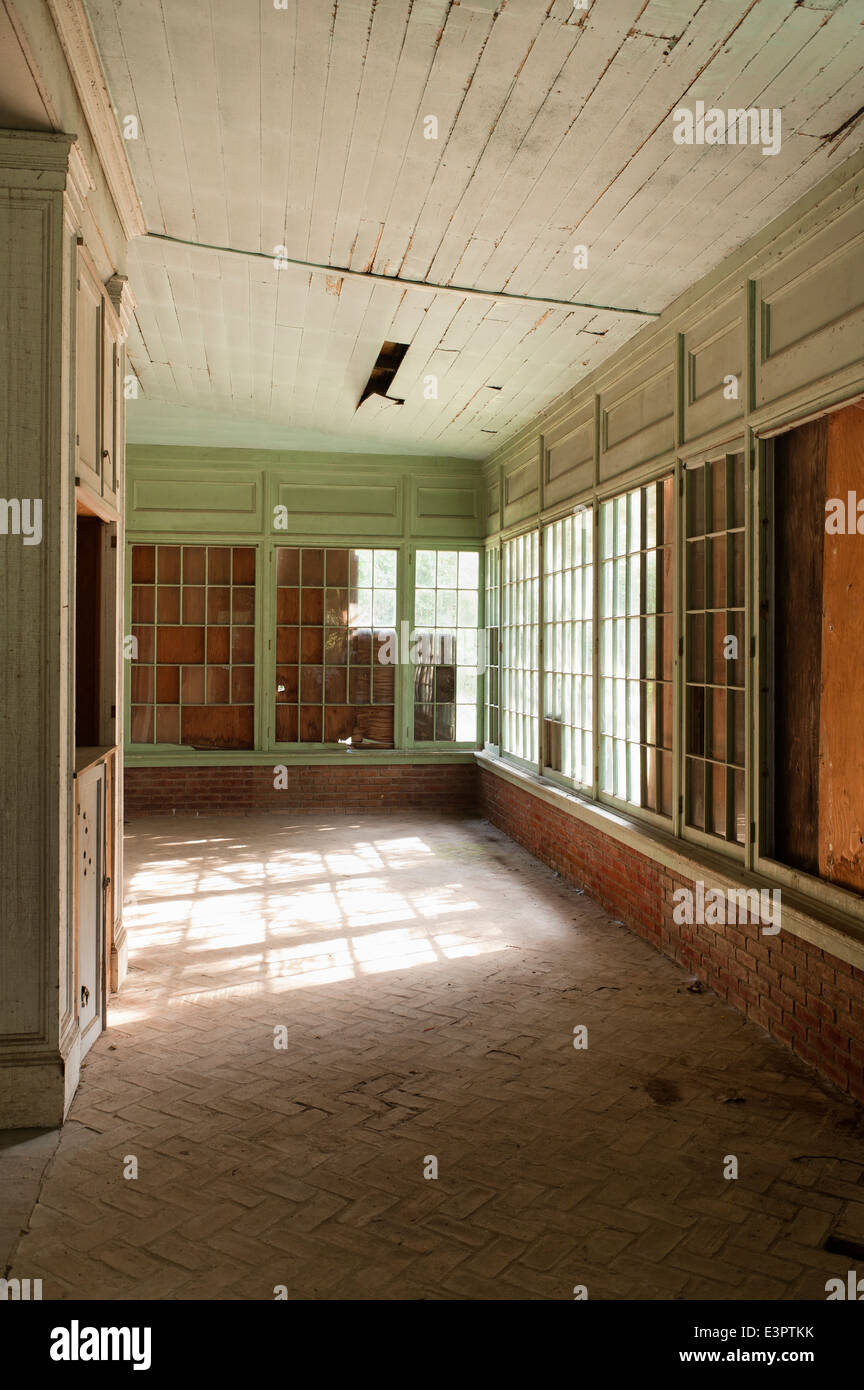 Pavimento in cotto nella vecchia veranda con intavolato windows, rotto la carenatura del soffitto e vernice incrinato Foto Stock