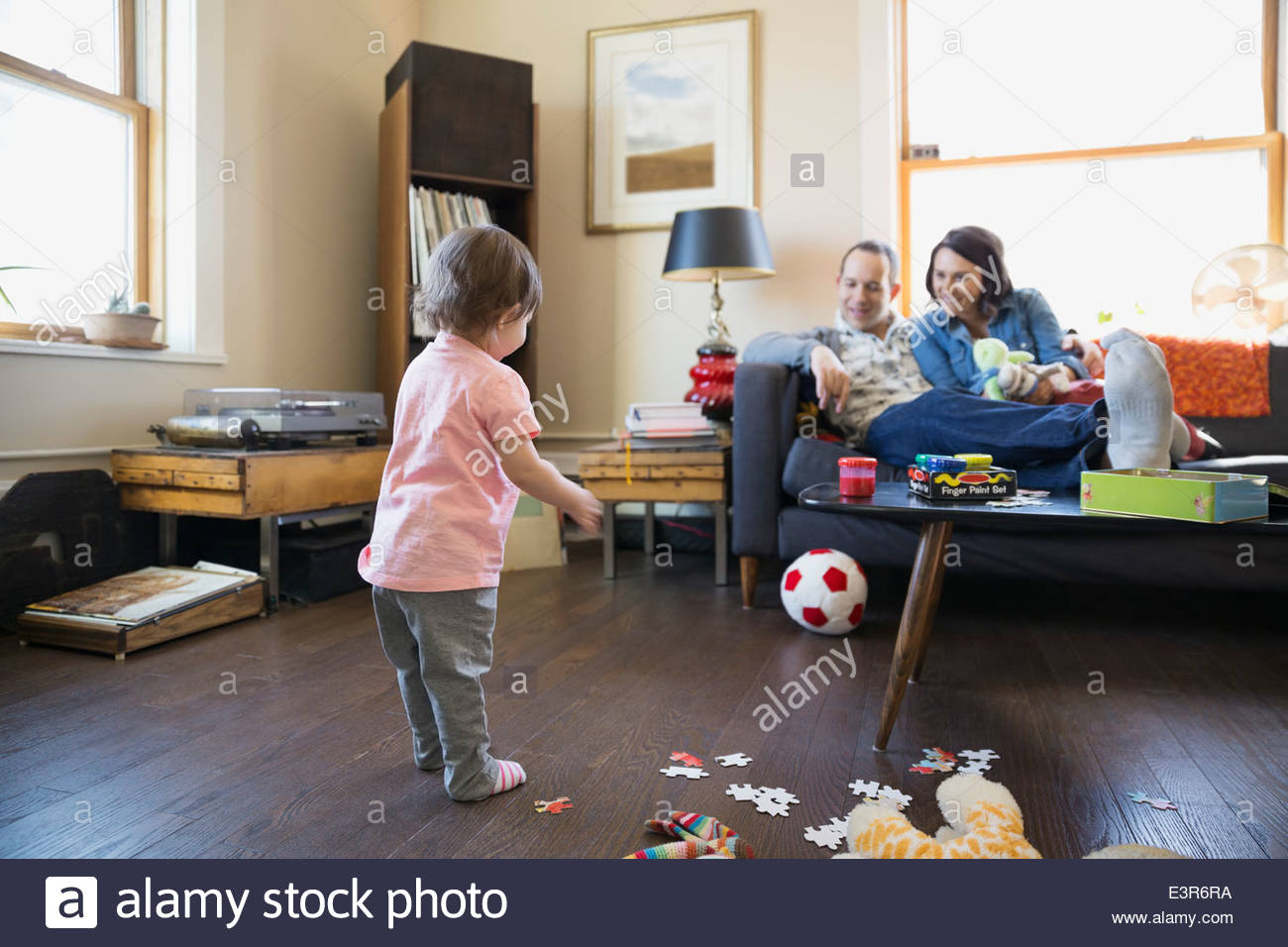 I genitori a guardare la nostra bambina gioca con la palla calcio Foto Stock