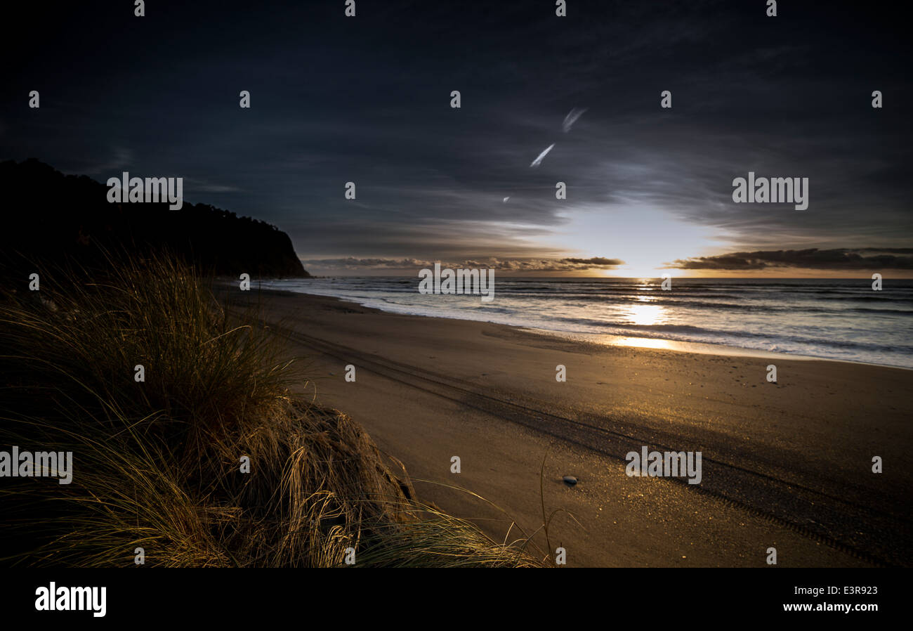 Okarito faggio, Sud Westland, Nuova Zelanda guardando verso sud al tramonto. Foto Stock