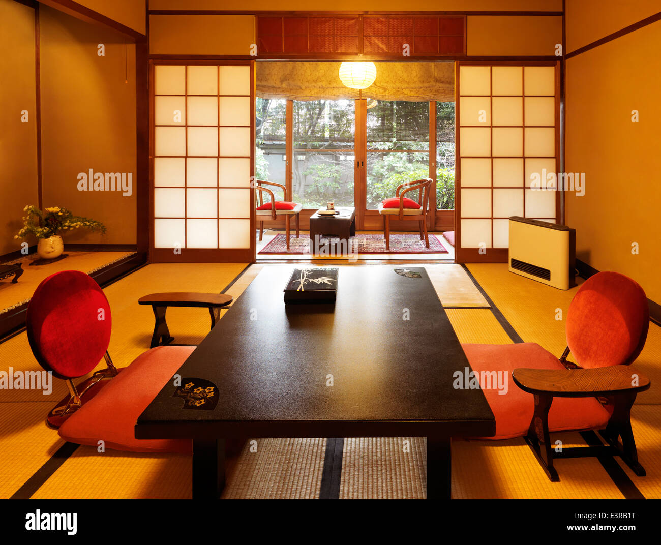 Camera giapponese interno in un ryokan con vista giardino a Kyoto, in Giappone. Tavolo da tè chabudai e zaisu sedie. Foto Stock