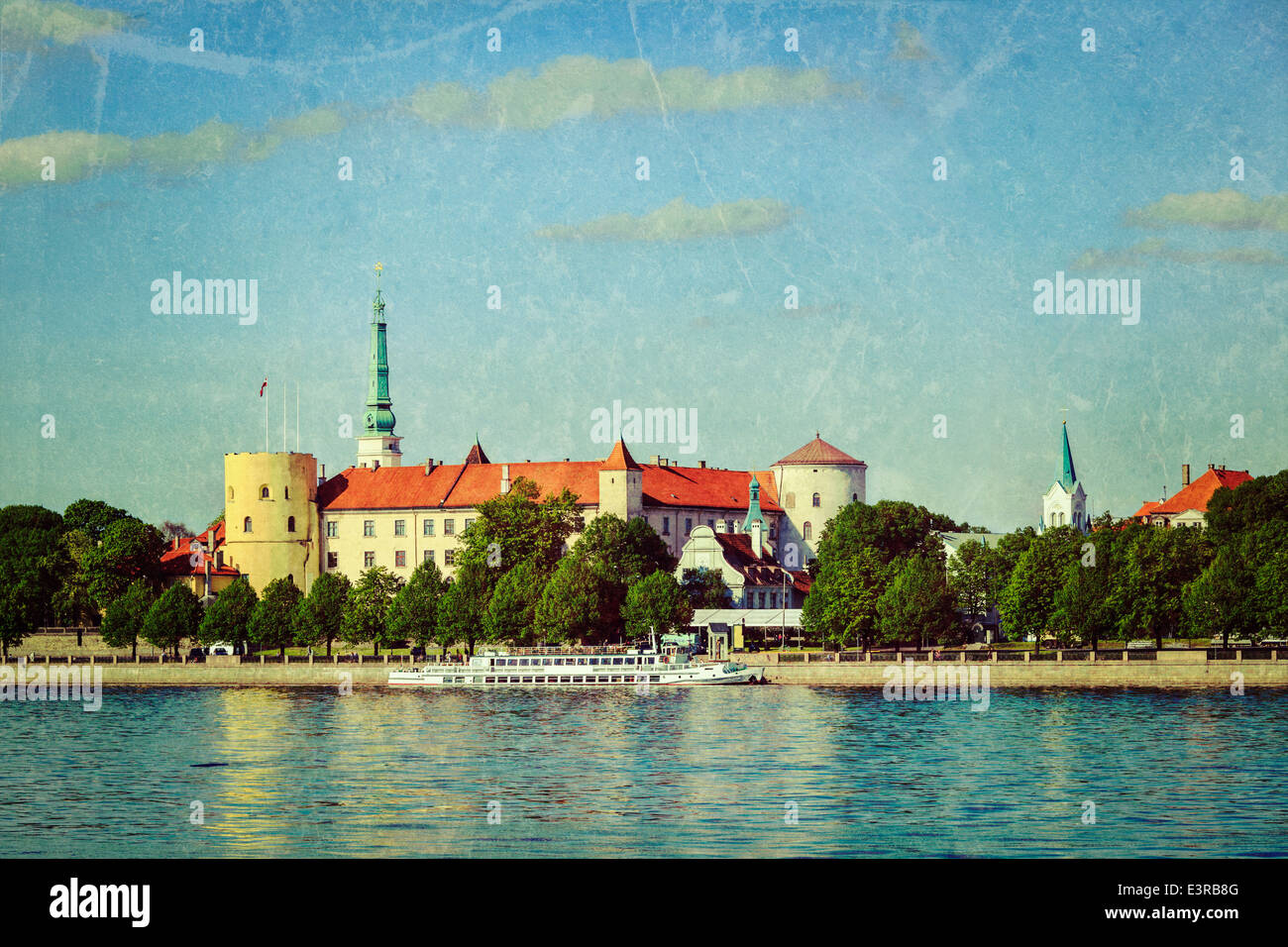 Vintage retrò hipster stile immagine di viaggio di vista del Castello di Riga oltre il fiume Daugava con texture grunge sovrapposto. Riga, Lettonia Foto Stock