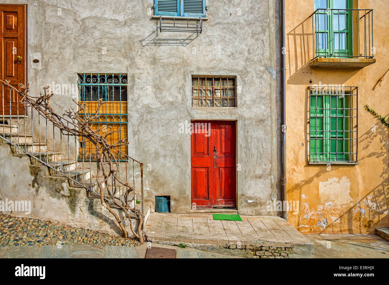 La facciata della tipica casa italiana con colorate le finestre e le porte nella città di Saluzzo in Piemonte, Italia settentrionale. Foto Stock