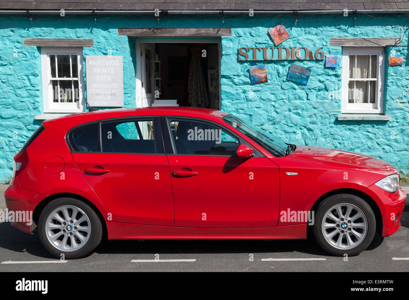 Rosso brillante auto di fronte all edificio color turchese, St Davids, Pembrokeshire Foto Stock