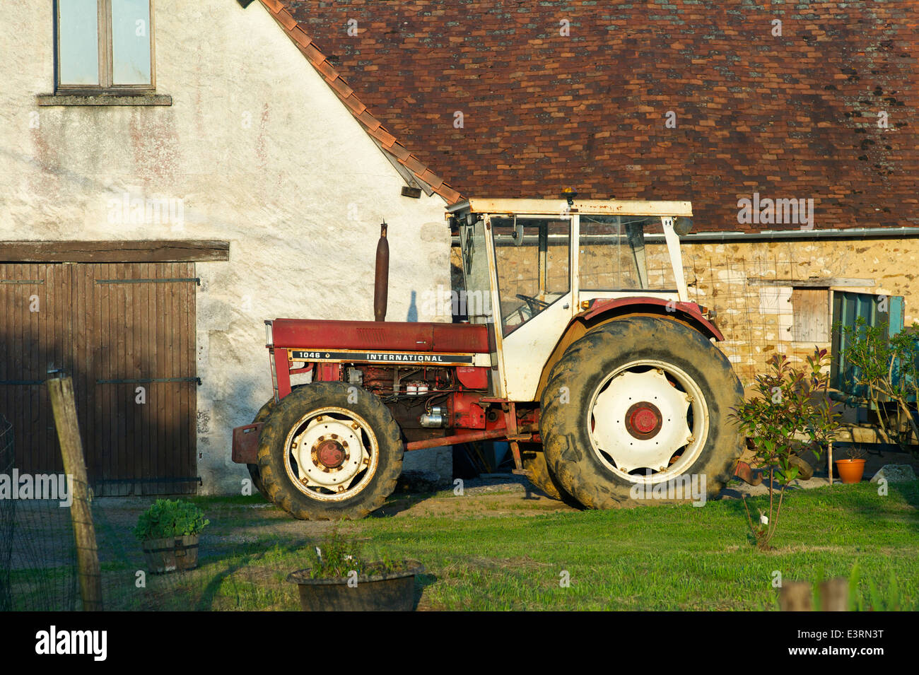 Un vintage trattore internazionale in una fattoria, Indre, Francia Foto Stock
