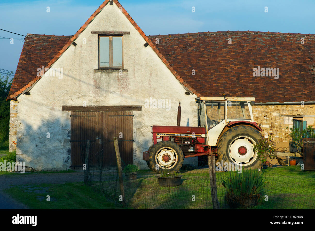 Un vintage trattore internazionale in una fattoria, Indre, Francia Foto Stock
