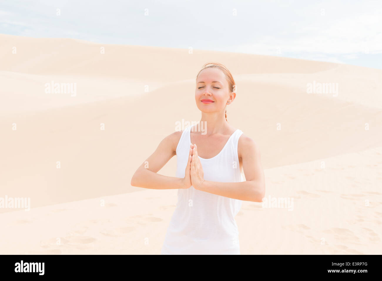 Giovane donna a praticare yoga nel deserto Foto Stock