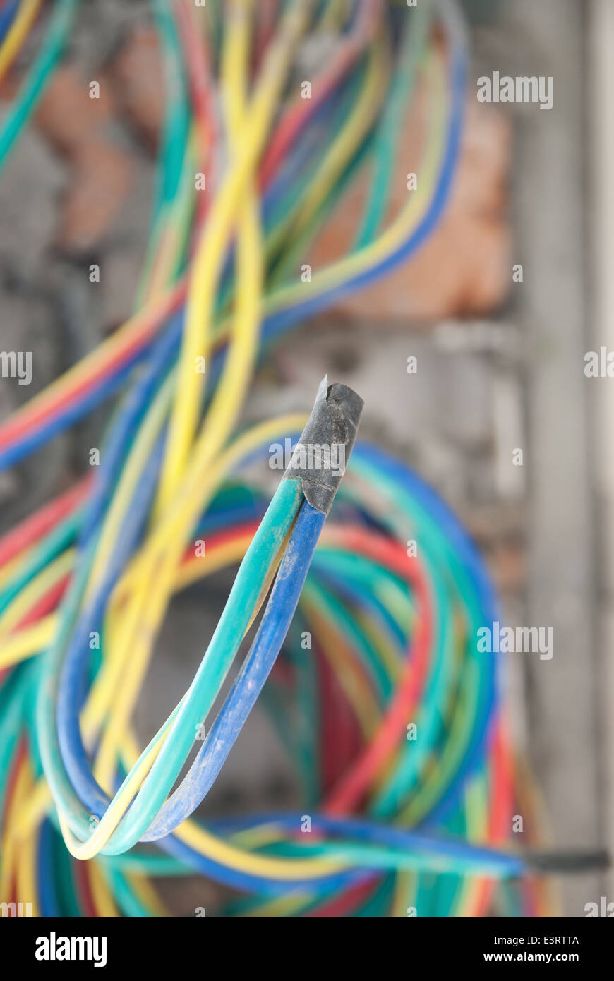 Multicolore di cavi elettrici sulla parete grezza Foto Stock