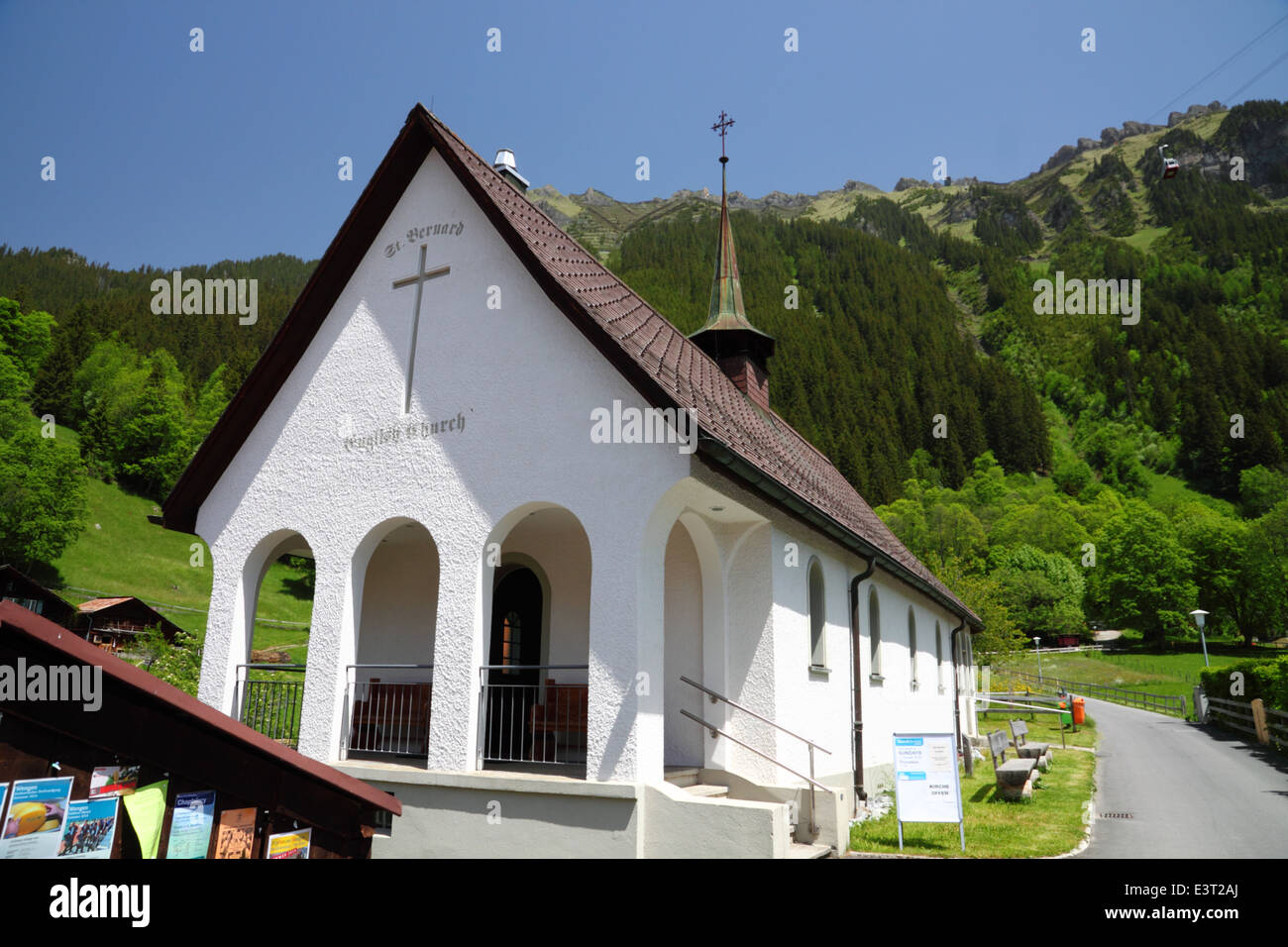 Una chiesa bianca con un campanile, in mezzo a scenari di montagna. Foto Stock