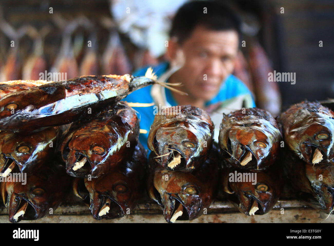 Manila, Filippine. Il 29 giugno, 2014. Un uomo musulmano vende tonno affumicato in una comunità musulmana a Manila, Filippine, 29 giugno 2014. I musulmani di tutto il mondo stanno osservando il primo giorno del mese di digiuno del Ramadan, durante il quale i musulmani trattenere dal mangiare e dal bere e fumare dall alba al tramonto. © Rouelle Umali/Xinhua/Alamy Live News Foto Stock