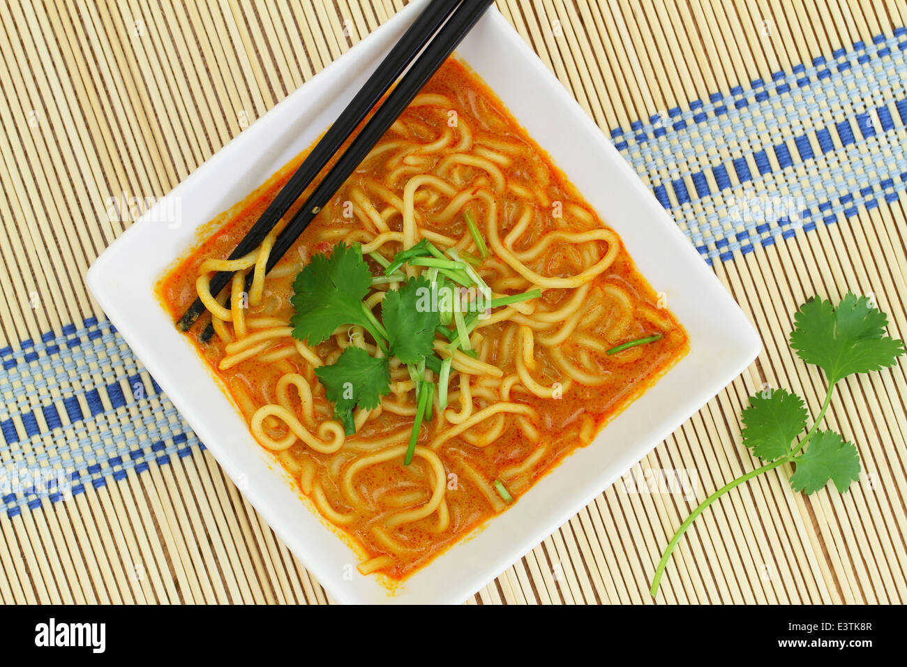 Hot Curry zuppa di noodle nella ciotola sul tappetino di bambù Foto Stock