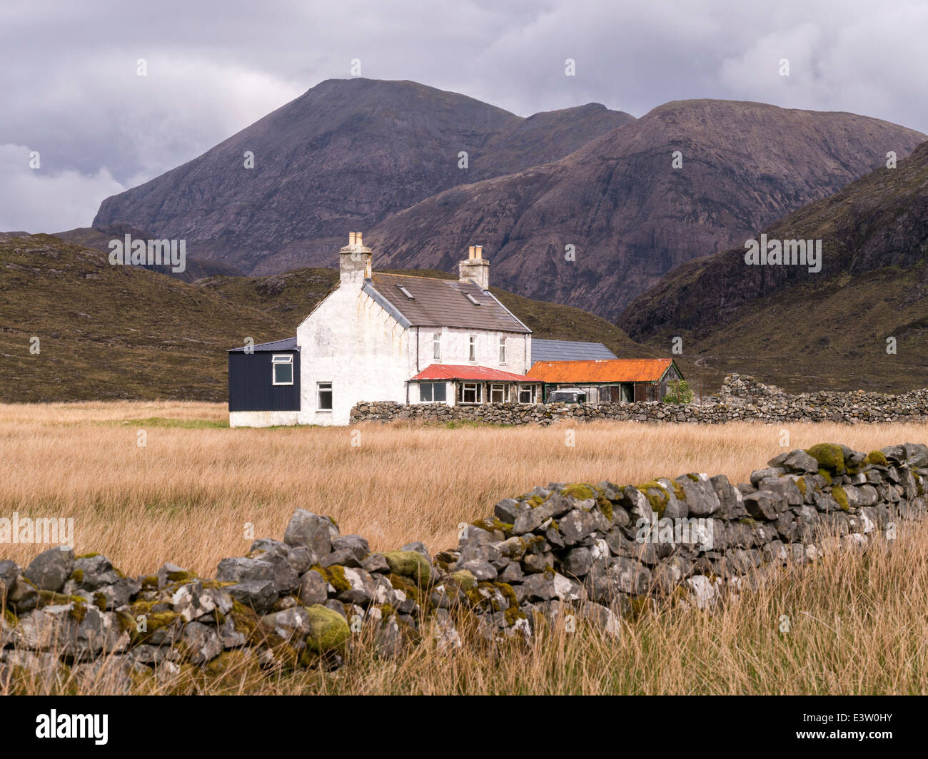 Remote dipinte di bianco casa in Camasunary bay con Red Cuillin montagne (Marsco & Ruadh Stac) oltre, Isola di Skye, Scotland, Regno Unito Foto Stock