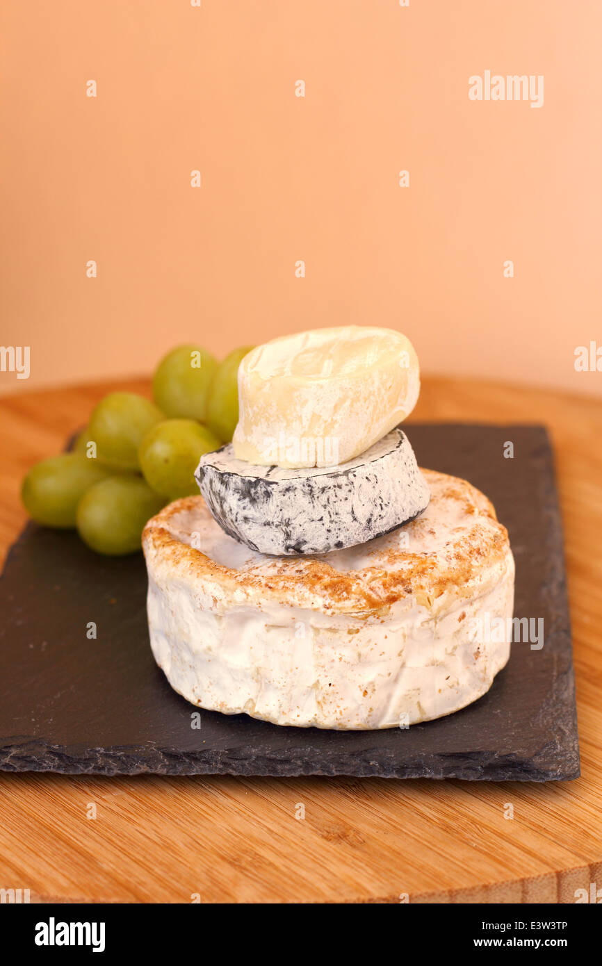 Pila di formaggio camembert e uva sulla tavola di legno Foto Stock