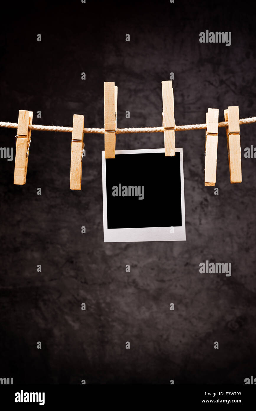 Fotografia della carta con instant photo frame attaccata alla corda con vestiti pin. Copia dello spazio per la vostra immagine. Foto Stock