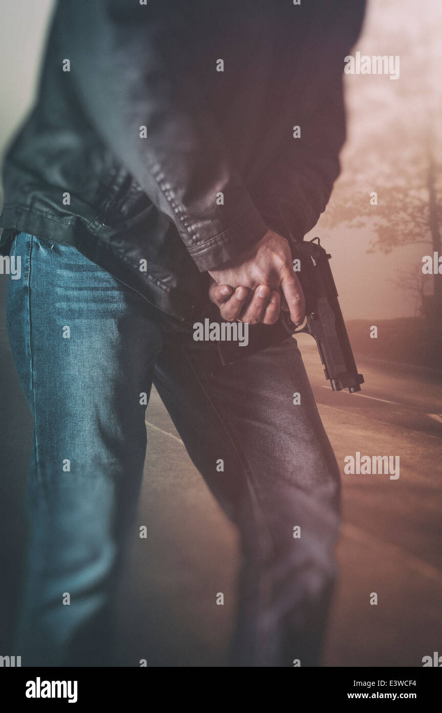 Uomo in possesso di una pistola Foto Stock