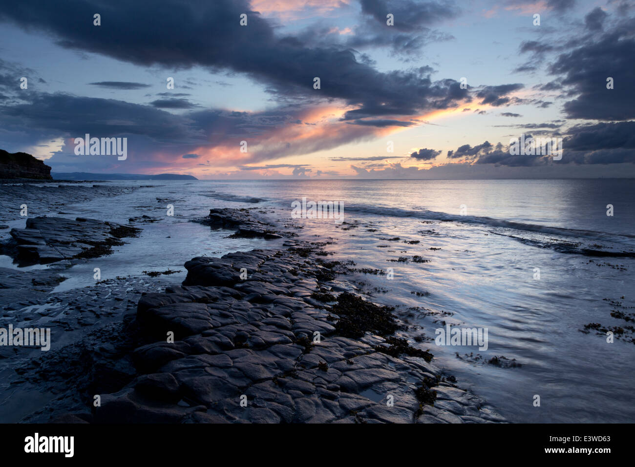 Lastra di pietra calcarea esposta dalla marea calante in una sera d'estate. Spiaggia tra Kilve e East Quantoxhead. Foto Stock