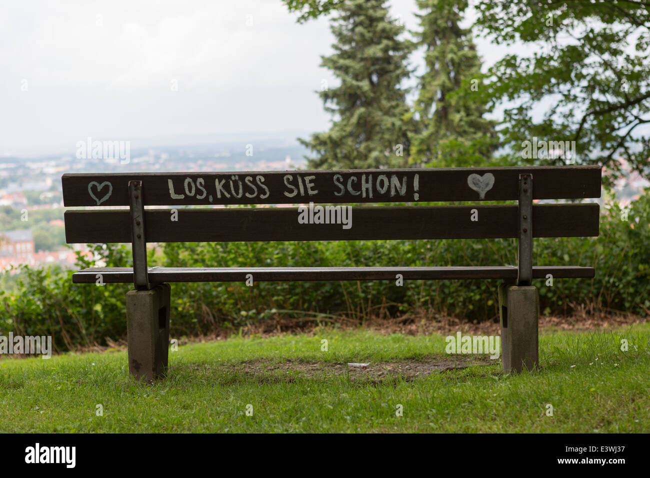 Una panchina nel parco con parole in tedesco, "Vai su, baciarla" Foto Stock