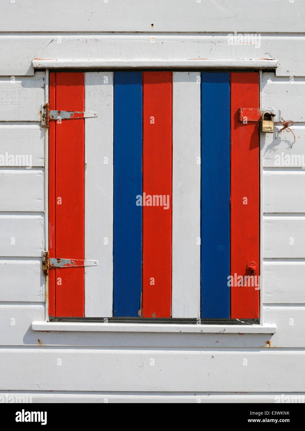 Un colorato di rosso, bianco e blu persiana su una spiaggia capanna a Southwold. Foto Stock