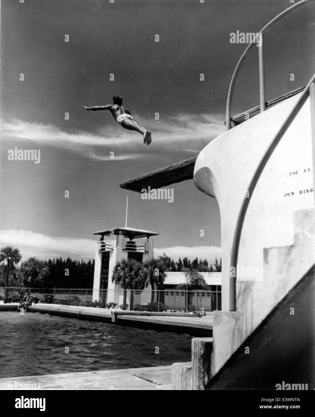 Questa immagine cattura un subacqueo presso la piscina Lido Beach di Sarasota, Florida. La piscina dispone di tavole da immersione ed è un popolare sito ricreativo per residenti e turisti. La scena mette in risalto la cultura del nuoto all'aperto e le strutture ricreative della zona. Foto Stock