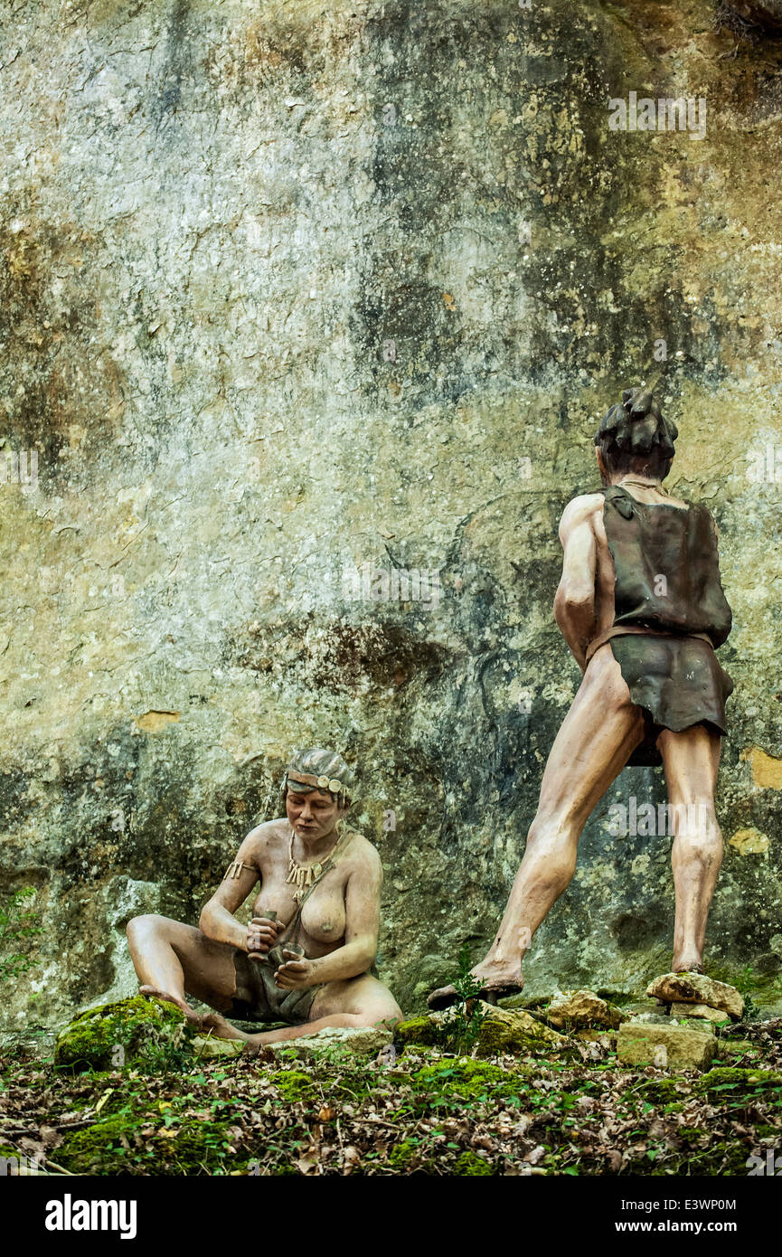 Cro-Magnon donna e uomo pittura animali sulla roccia a Prehisto Parc circa la vita preistorica a Tursac, Dordogne, Francia Foto Stock