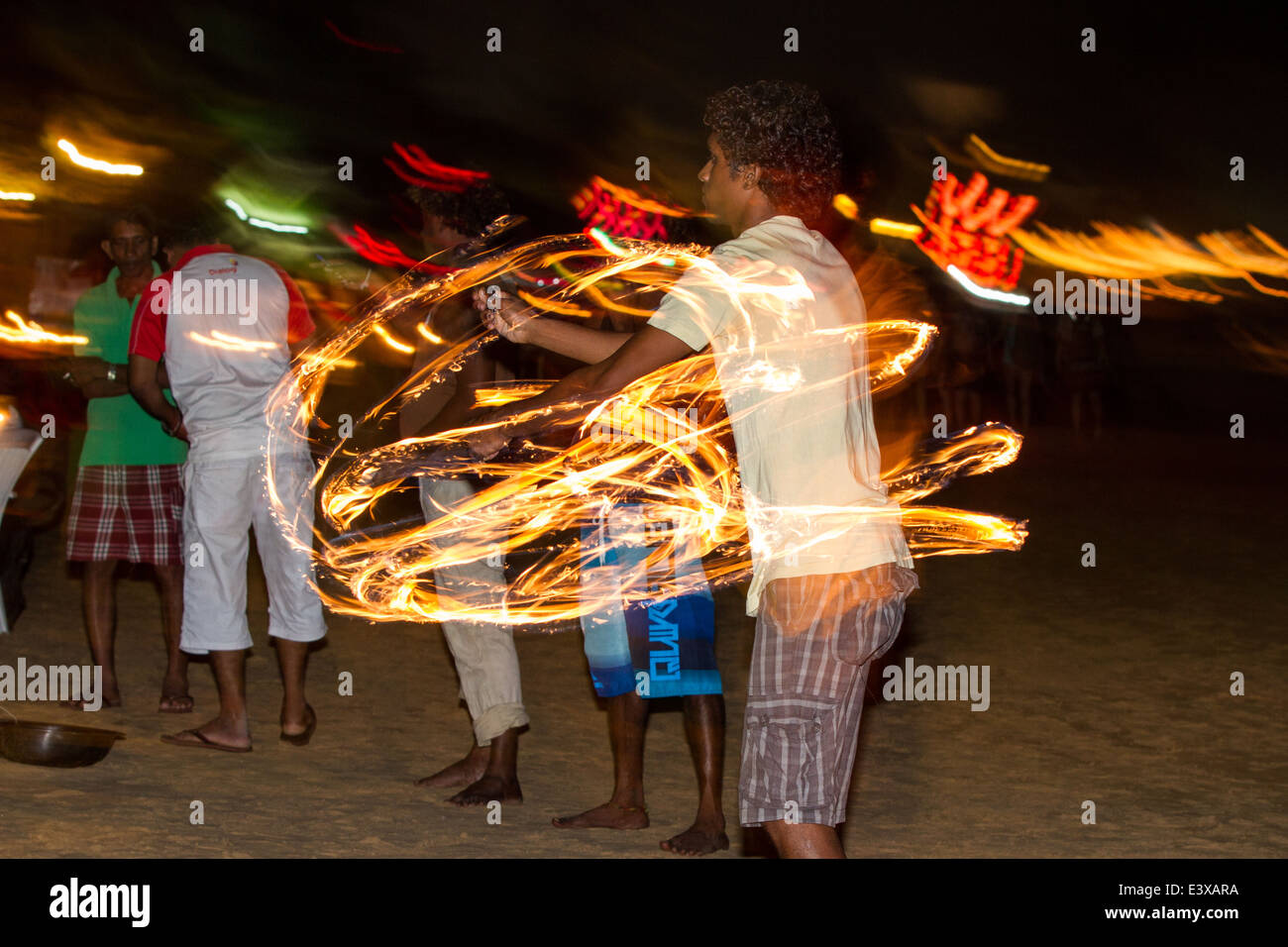 Fire Dancer un incendio la ballerina esegue trucchi e nutre la notte tempo diners turistico sulla spiaggia Mirissa in Sri Lanka Foto Stock