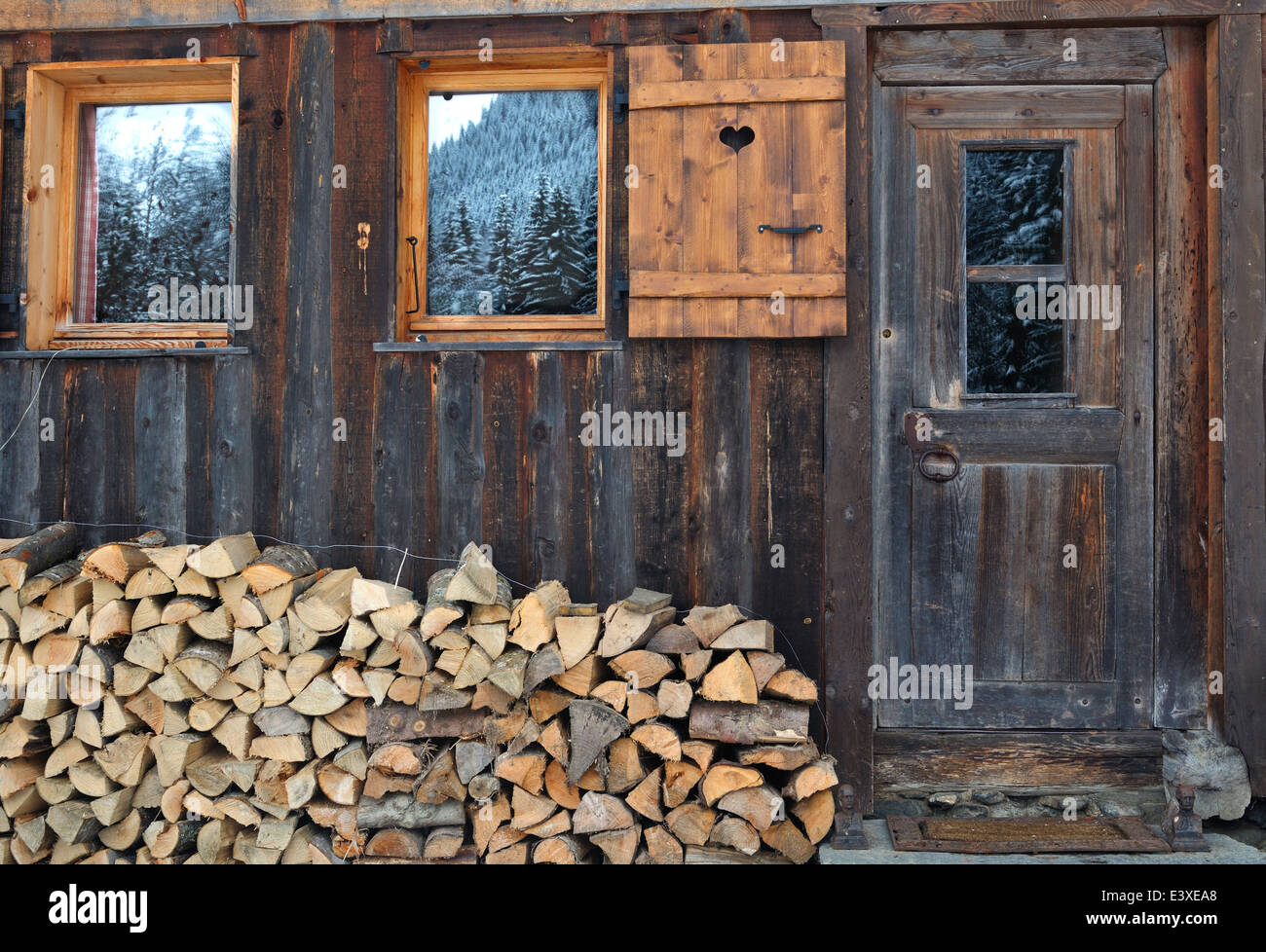 Legna da ardere impilati nella parte anteriore di uno chalet in legno Foto Stock