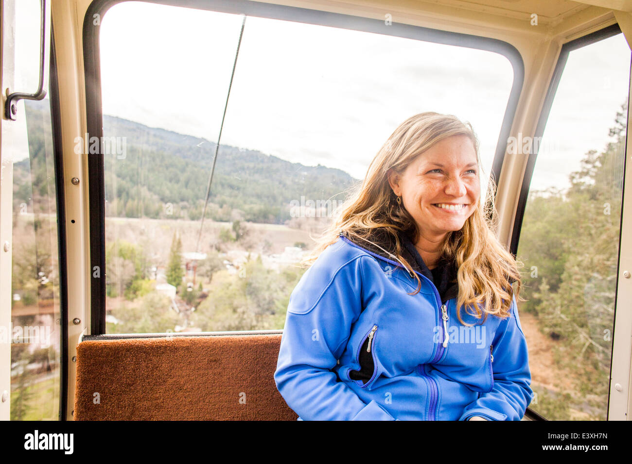 La donna caucasica equitazione in aerial tram Foto Stock