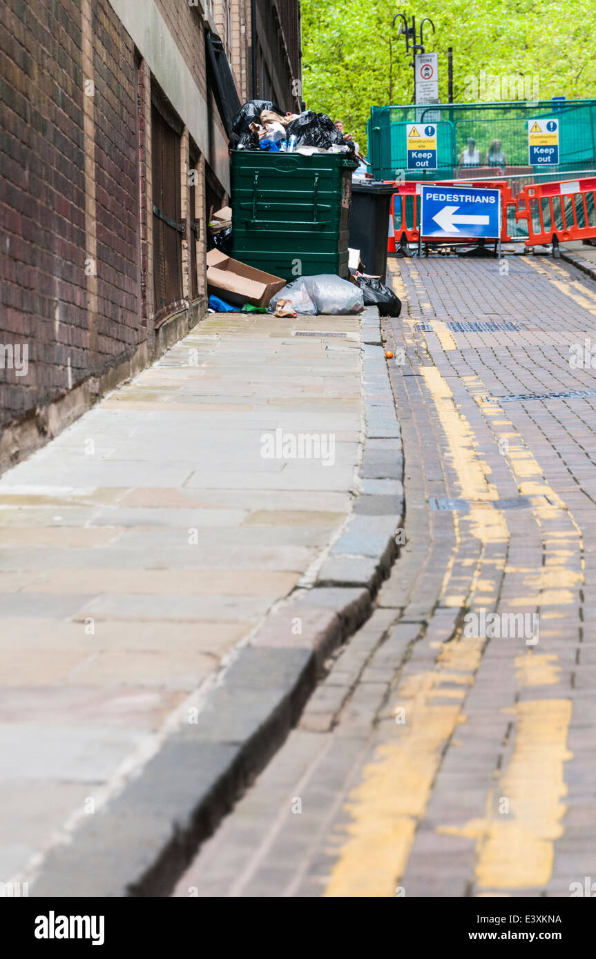 Guardando lungo una strada posteriore in Birmingham con un segno che figurano a dirigere i pedoni in un cassonetto Foto Stock