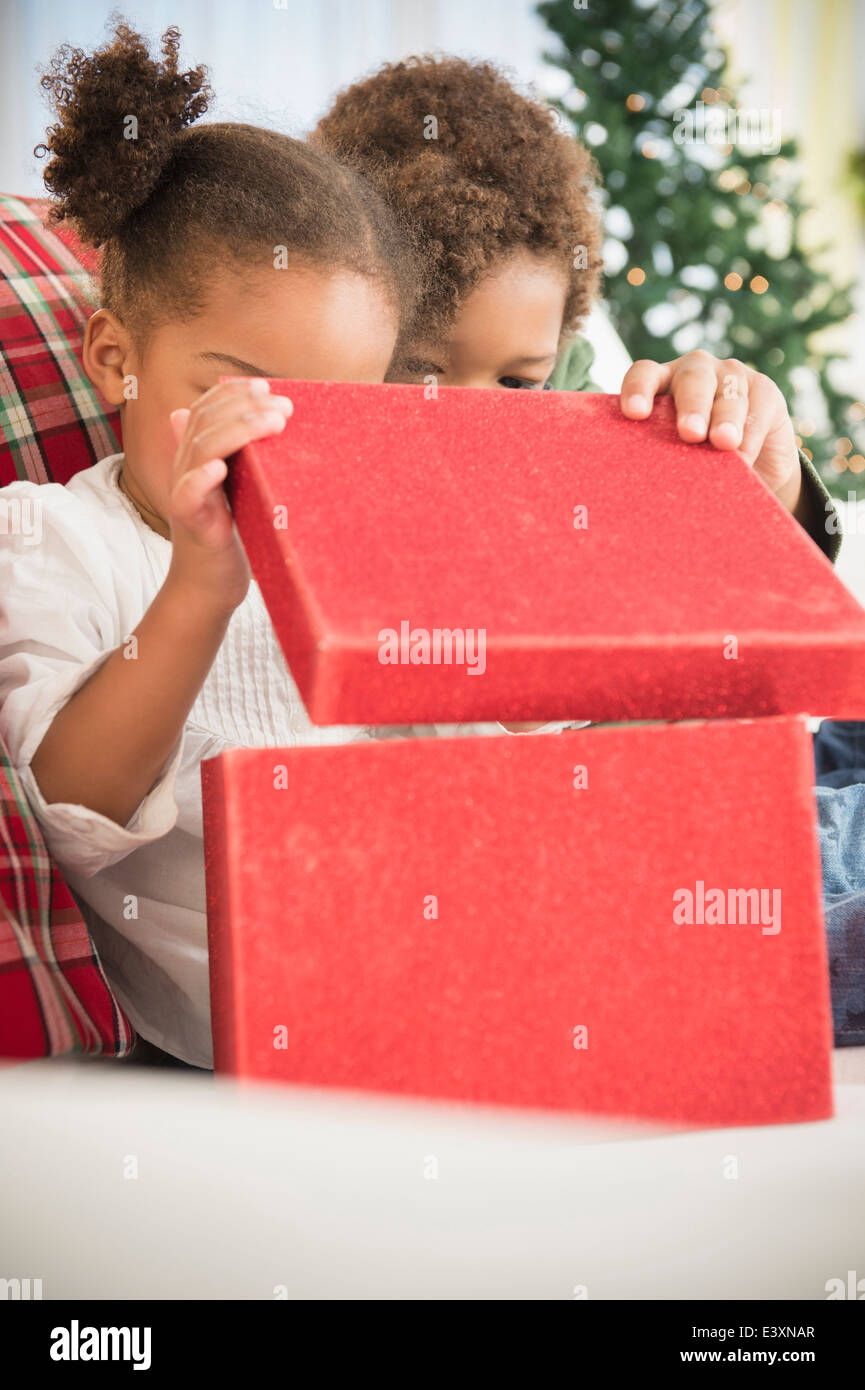 Bambini neri apertura regali di Natale sul divano Foto Stock
