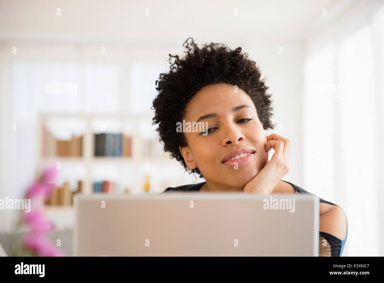 Nero donna utilizzando laptop a tavola Foto Stock
