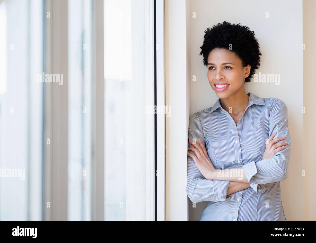 Imprenditrice nero sorridendo dalla finestra Foto Stock