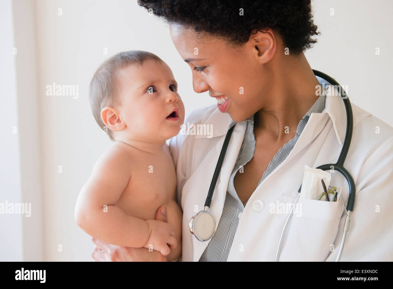 Sorridente medico tenendo baby Foto Stock