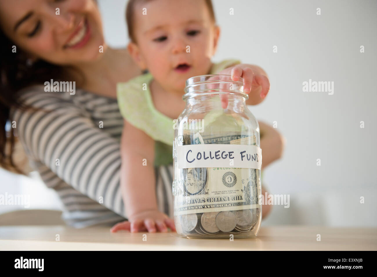 La madre e il bambino mettere soldi in college fund Foto Stock