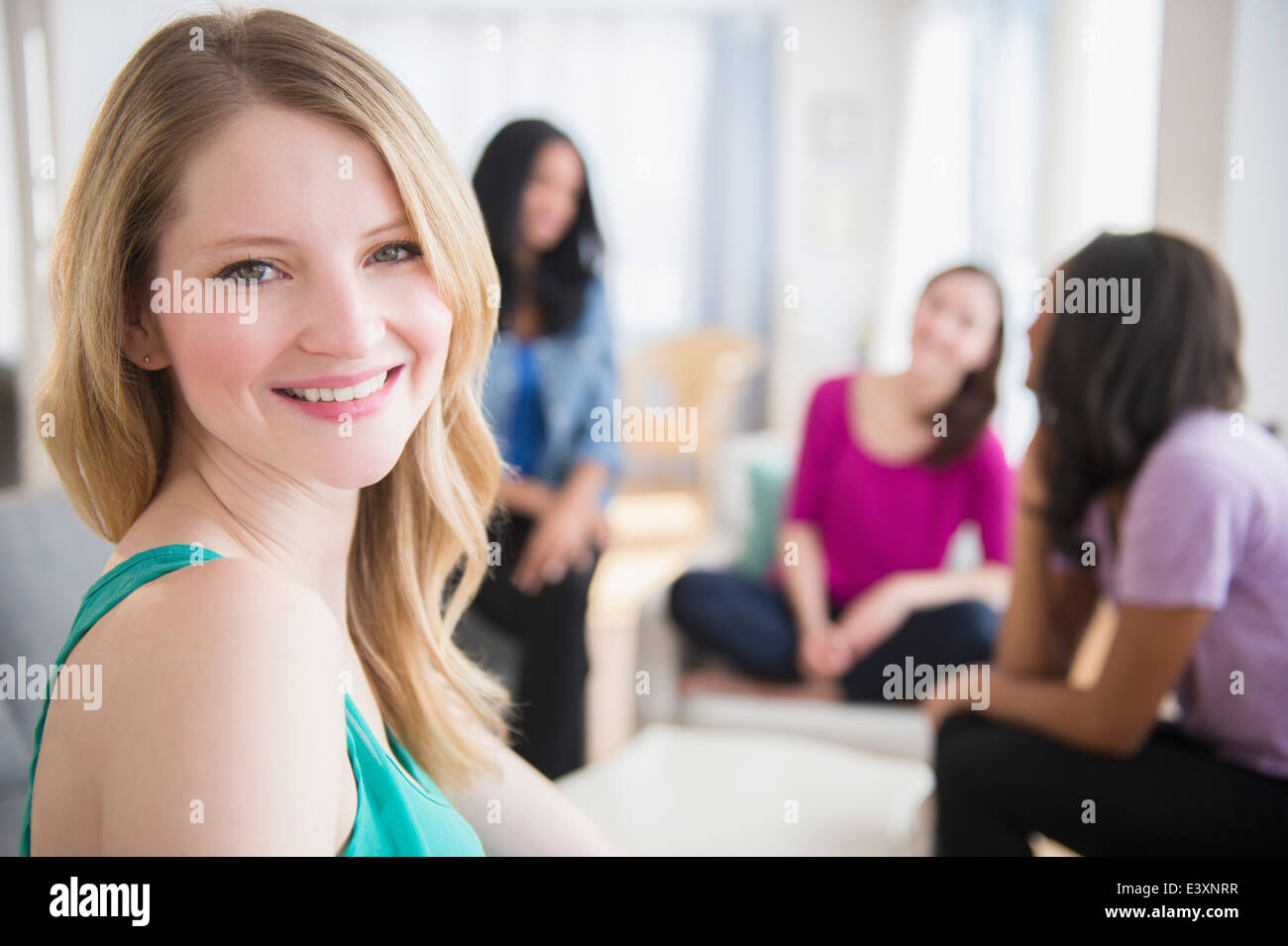 Donna sorridente seduto con gli amici Foto Stock