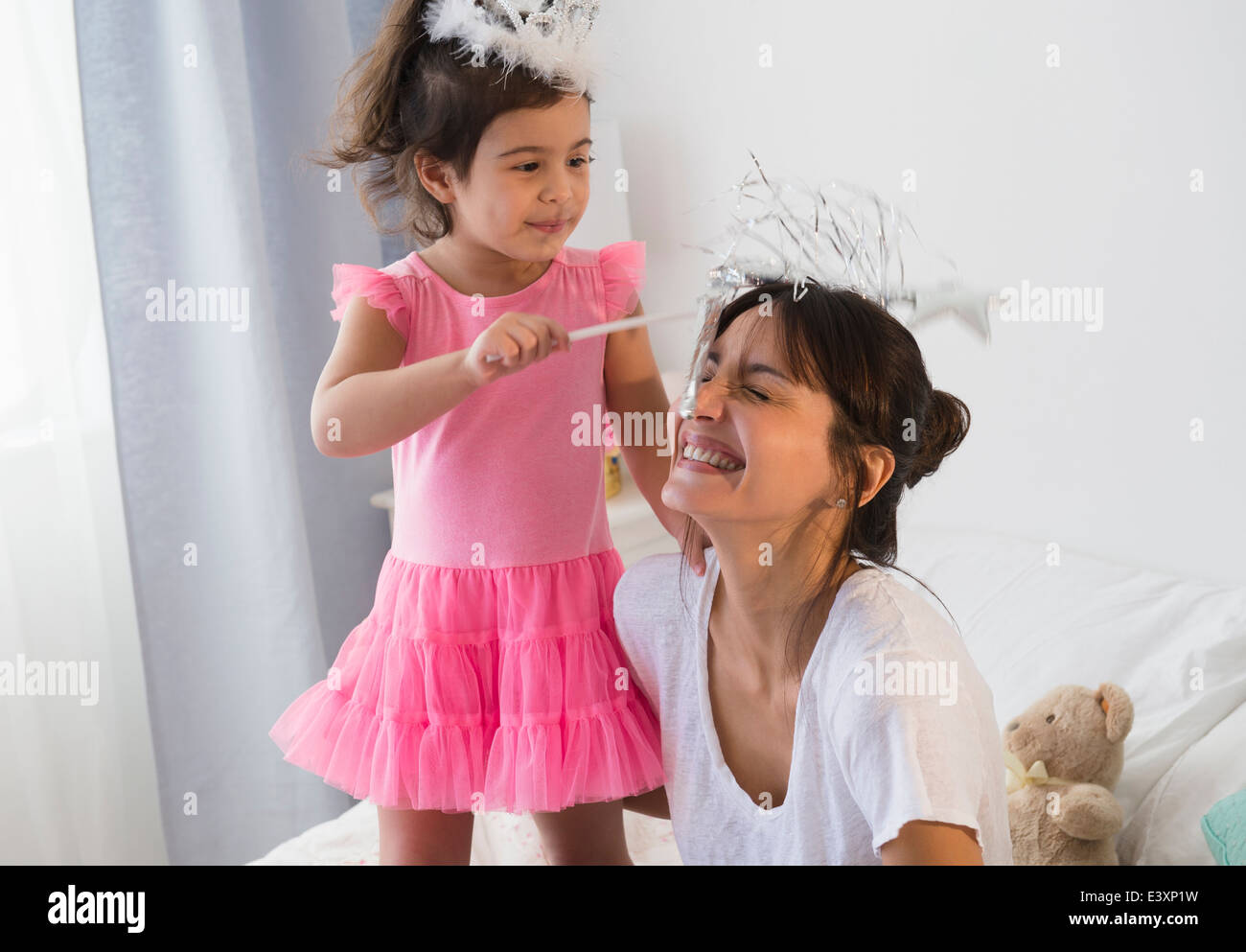 Ispanico madre e figlia gioca dress up sul letto Foto Stock