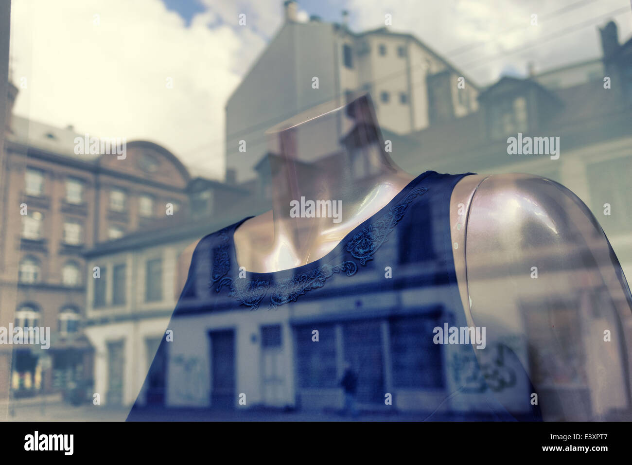 Riflesso nella finestra della città con un abito su un manichino Foto Stock