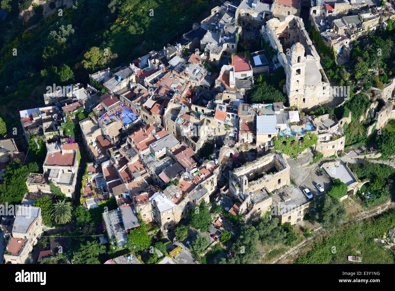 VISTA AEREA. Arroccato borgo medievale, pesantemente danneggiato da un terremoto, restaurato da artisti. Bussana Vecchia, Provincia di Imperia, Liguria, Italia. Foto Stock