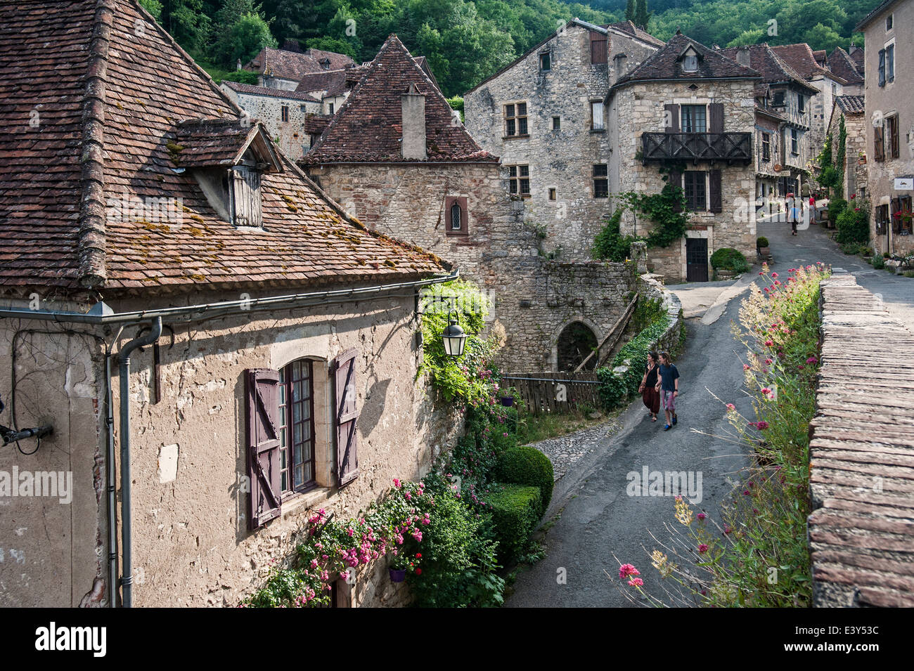 I turisti a piedi attraverso il villaggio medievale Saint-Cirq-Lapopie, Lot, Midi-Pirenei, Francia Foto Stock
