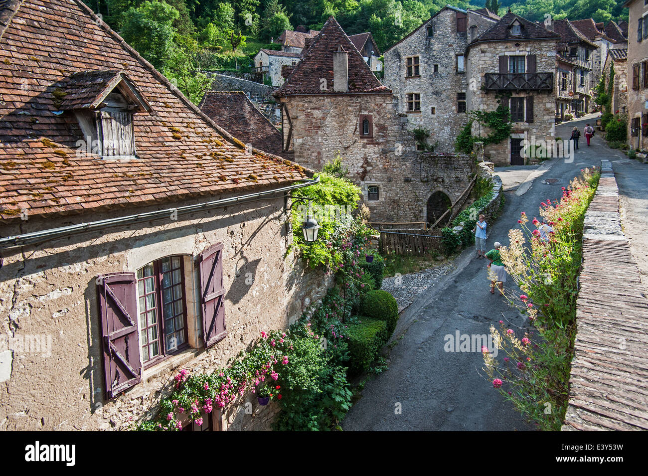 I turisti a piedi attraverso il villaggio medievale Saint-Cirq-Lapopie, Lot, Midi-Pirenei, Francia Foto Stock