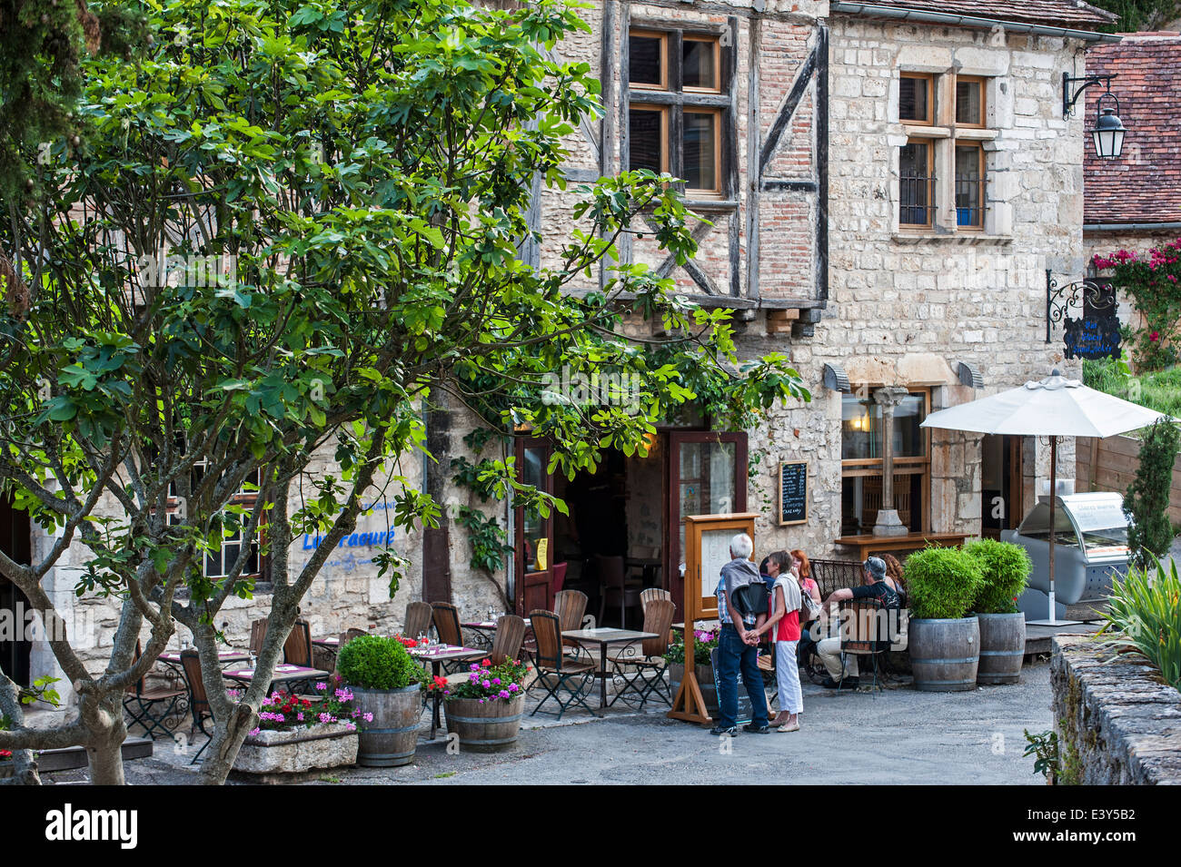 I turisti in visita a ristorante nel borgo medievale Saint-Cirq-Lapopie, Lot, Midi-Pirenei, Francia Foto Stock