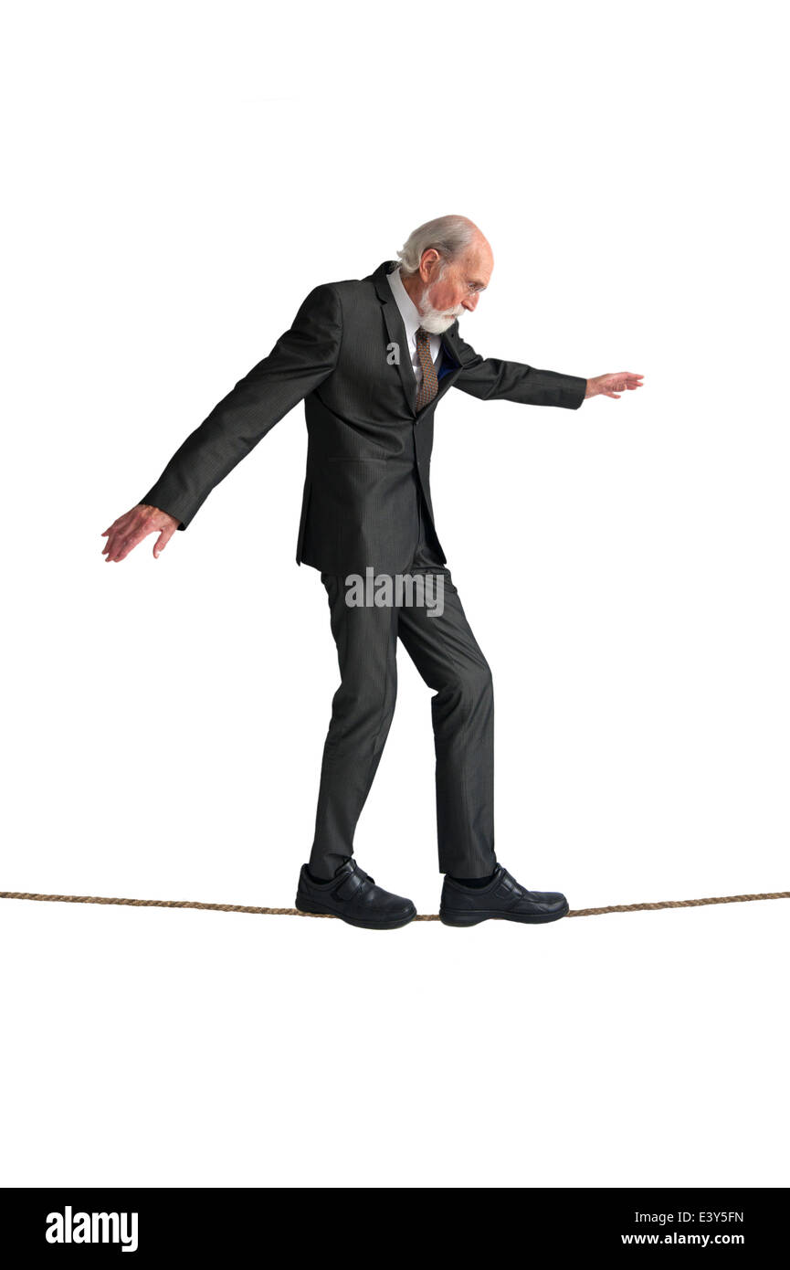Senior man walking un funambolico isolato su bianco Foto Stock