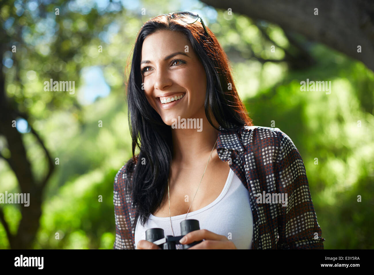 Metà donna adulta di osservazione degli uccelli in foresta Foto Stock