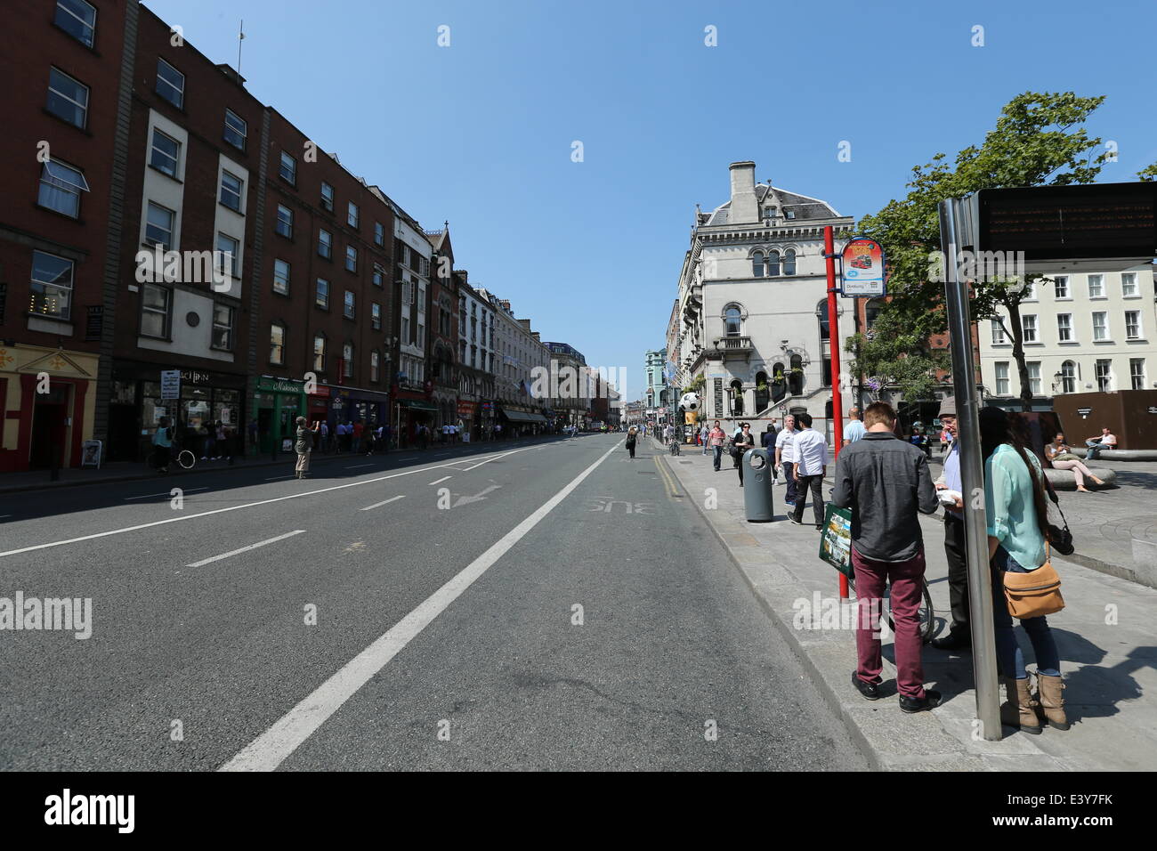 Dublino, Irlanda. 01 Luglio, 2014. La gente in attesa ad una fermata di autobus a Dame Street nel centro di Dublino dove Gardai spianato la strada del traffico dopo un uomo occupato il tetto dell'Ulster Bank building. Gardai e i servizi di emergenza risponde all'incidente guardato da centinaia nella capitale irlandese. Credito: Brendan Donnelly/Alamy Live News Foto Stock