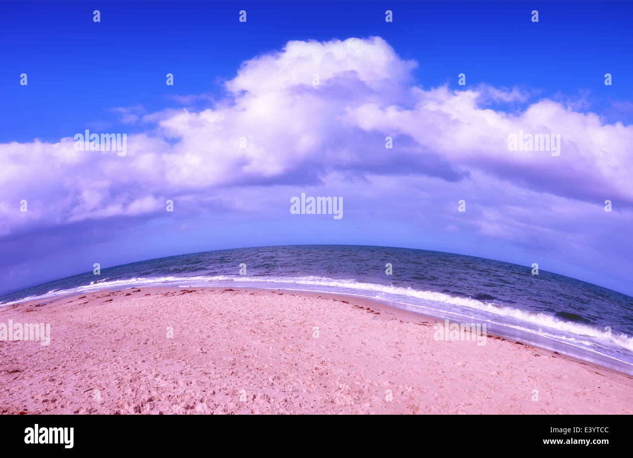 Vista fisheye di spiaggia di sabbia e il mare con il cielo blu e nuvole bianche. Foto Stock