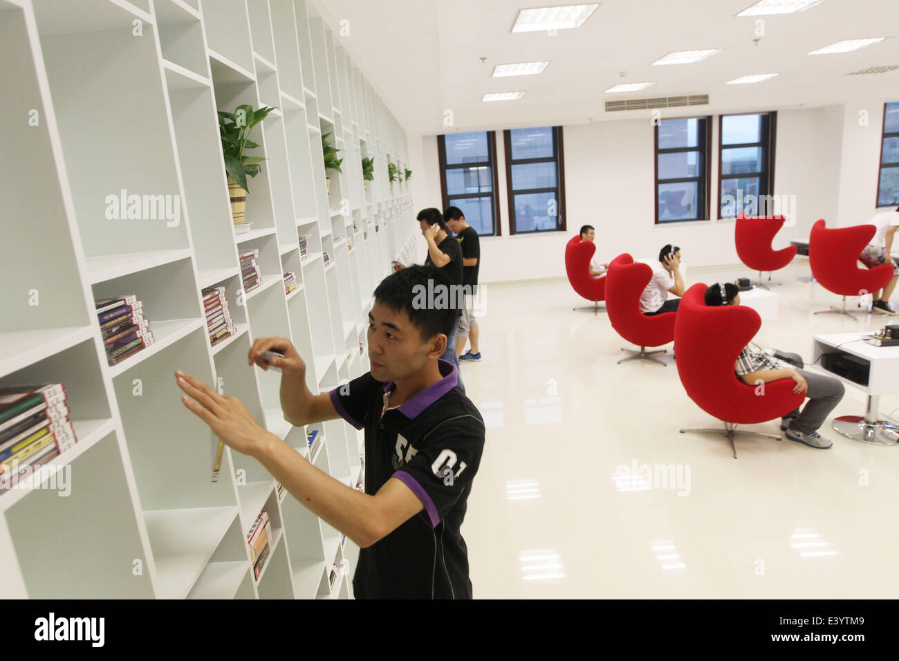 Wenzhou, cinese della Provincia di Zhejiang. 1 Luglio, 2014. Residenti selezionare CD su uno scaffale in una libreria musicale in Ouhai distretto della città di Wenzhou, est della Cina di Provincia dello Zhejiang, 1 luglio 2014. La libreria musicale qui, che coprono più di 200 metri quadrati, raccolti 592 CD musicali originali. Un totale di 15 girevoli poltrone vengono installati nella libreria per le persone di godere della musica. © Su Qiaojiang/Xinhua/Alamy Live News Foto Stock