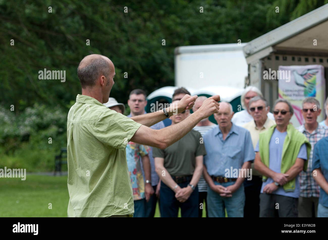 Un uomo a condurre una comunità coro a Leamington pace Festival, REGNO UNITO Foto Stock