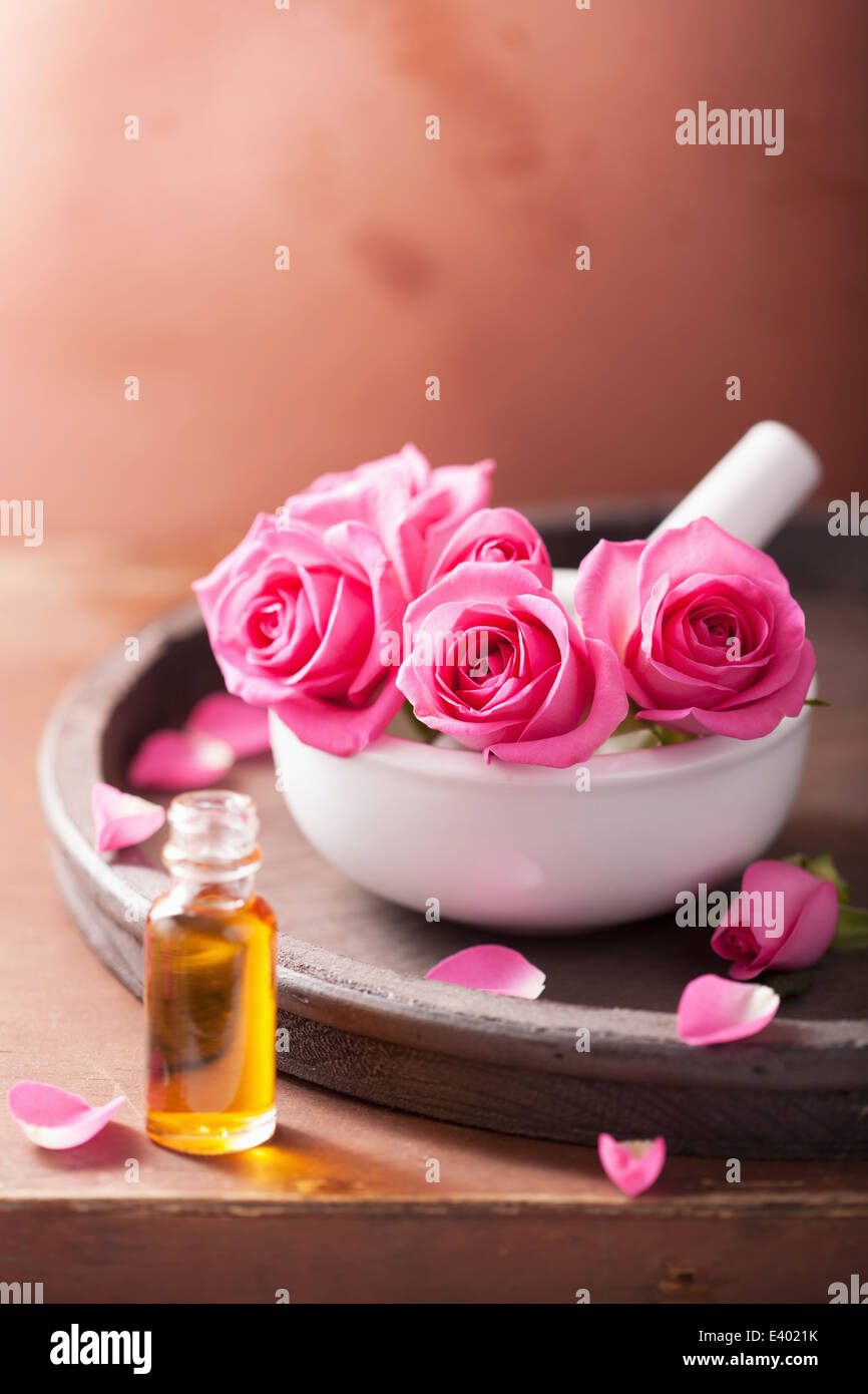 Mortaio con rose fiori e olio essenziale per aromaterapia e spa Foto Stock