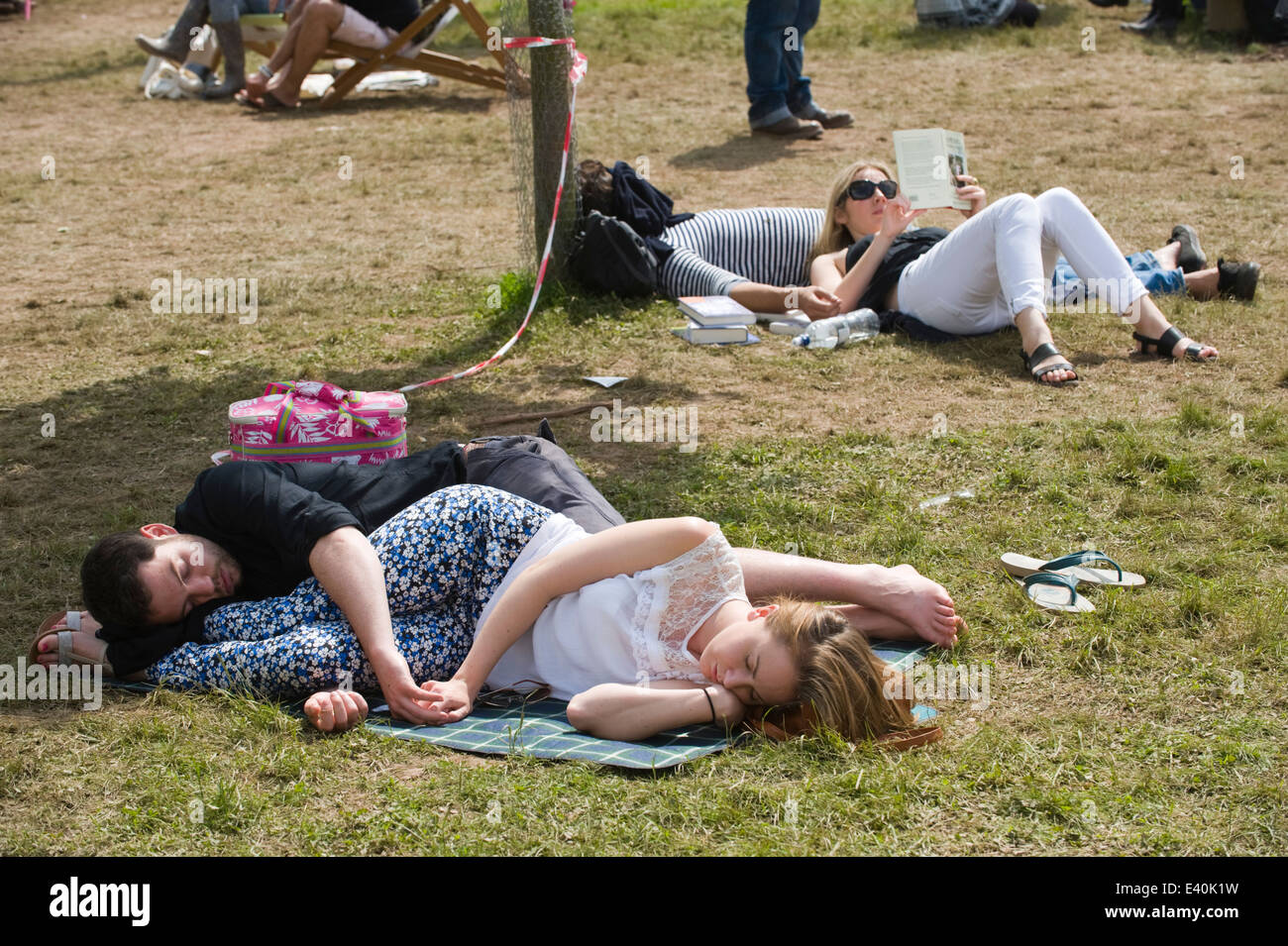 Coppia giovane di abbracciare giacente sul prato a Hay Festival 2014 ©Jeff Morgan Foto Stock
