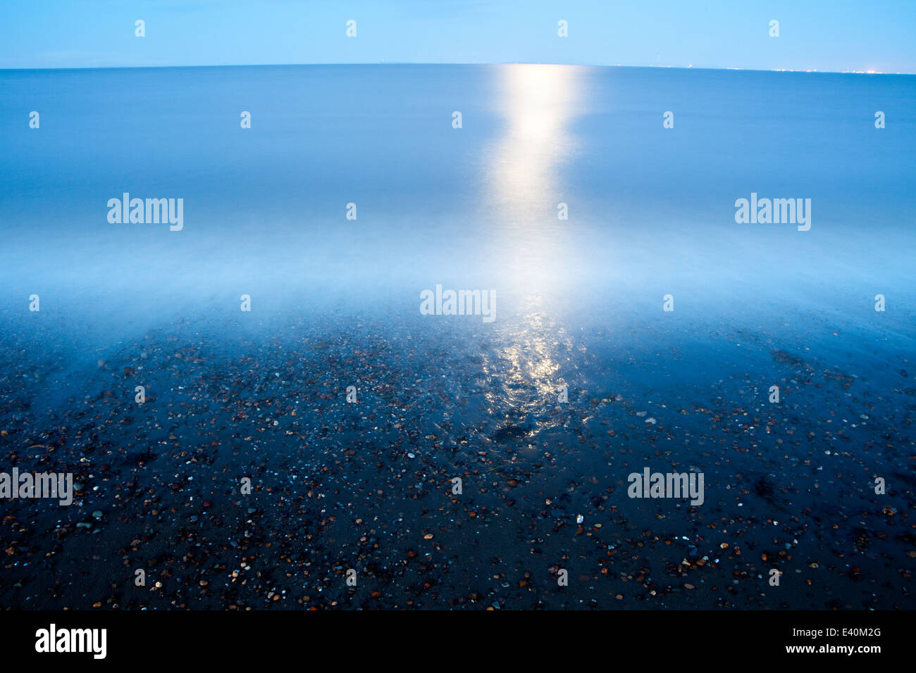 Inverno luna impostazione sulla spiaggia di Baia di sabbia, Somerset, Regno Unito Foto Stock